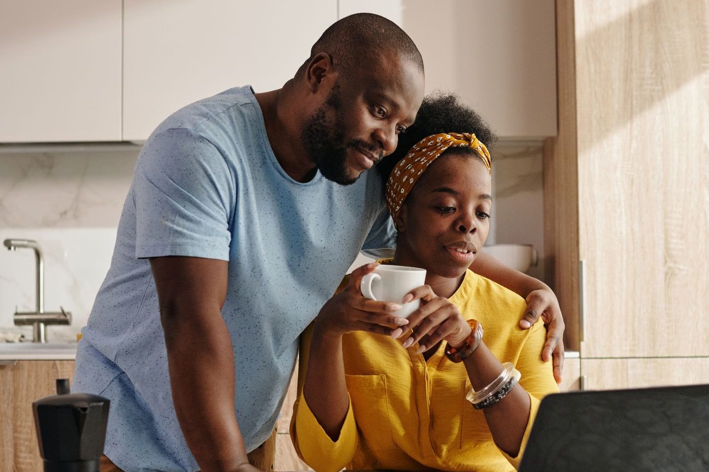 A couple at home together in their kitchen over morning coffee