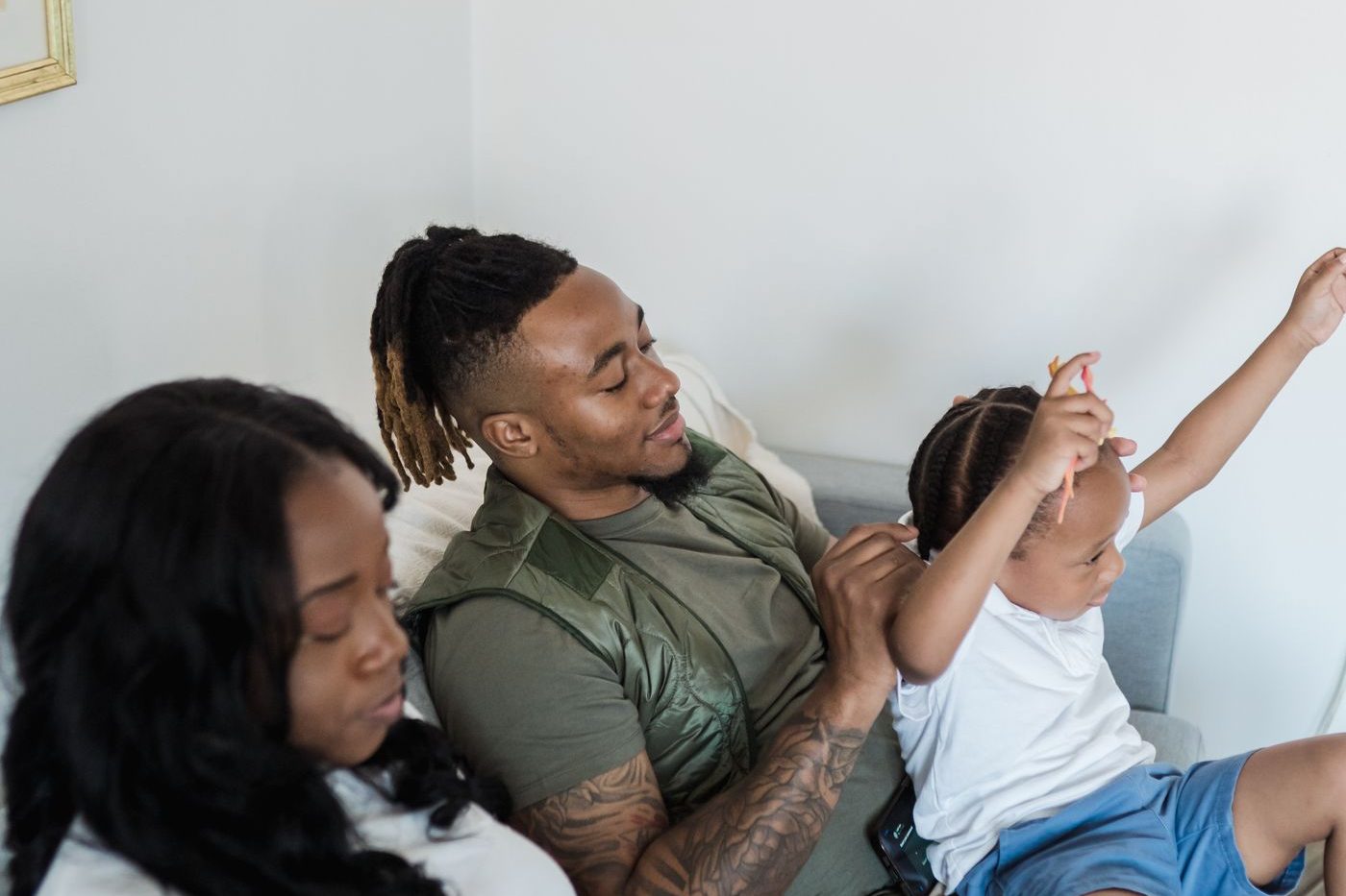 A family relaxed together on a sofa in their living room
