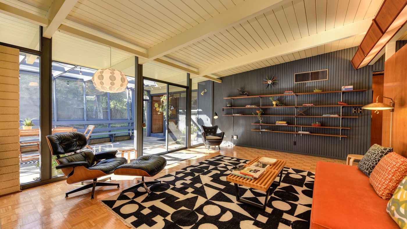 A mid-century living room with clerestory windows, warm wood and a graphic rug
