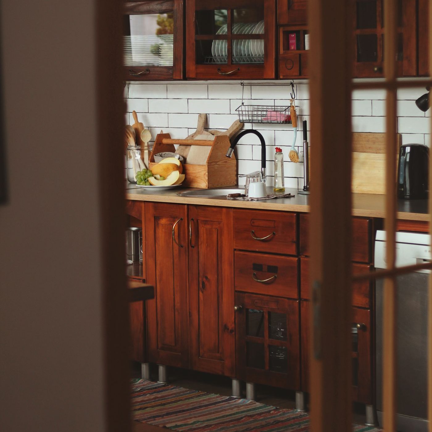A warm, dark kitchen corner with timber cabinetry and brass fittings