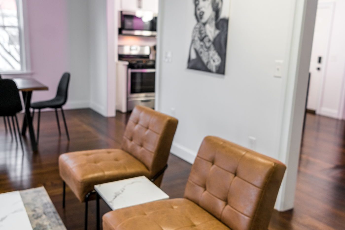 A lower-level sitting room with leather chairs and warm floors